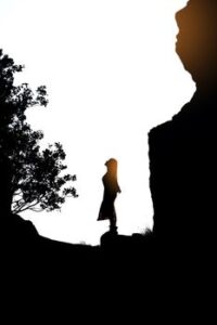 Dramatic silhouette of a woman standing on a cliff at sunset in Erzurum, Turkey, conveying freedom and adventure.